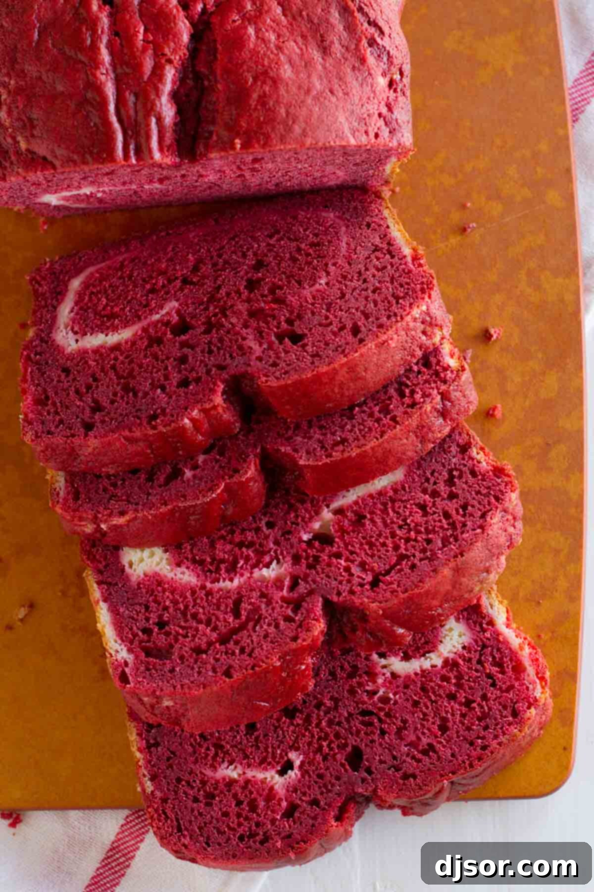 Loaf of red velvet quick bread with cream cheese filling, freshly baked and ready to be sliced.