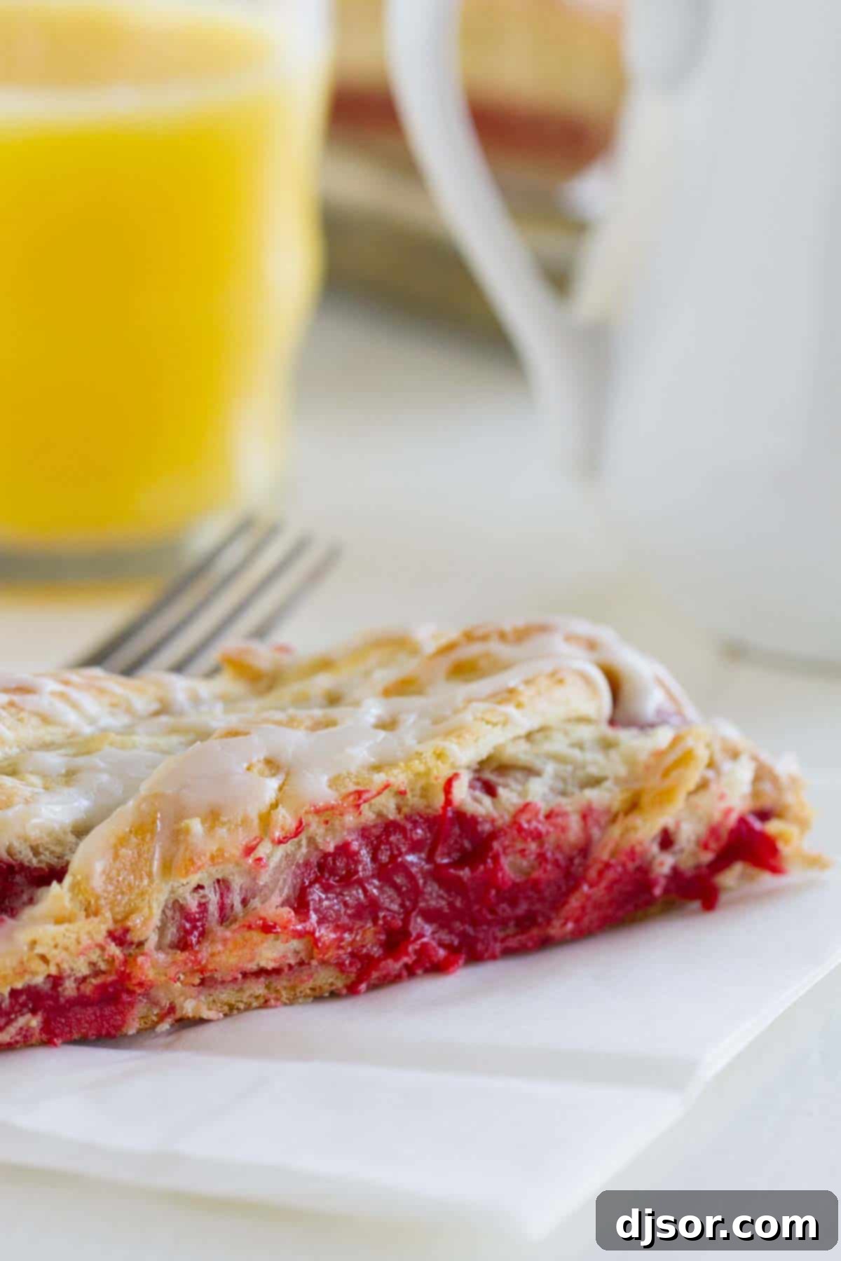 Decadent Red Velvet Cream Cheese Danish 5 A delicious slice of Red Velvet Cream Cheese Danish, with a glass of orange juice in the background, ready for breakfast.