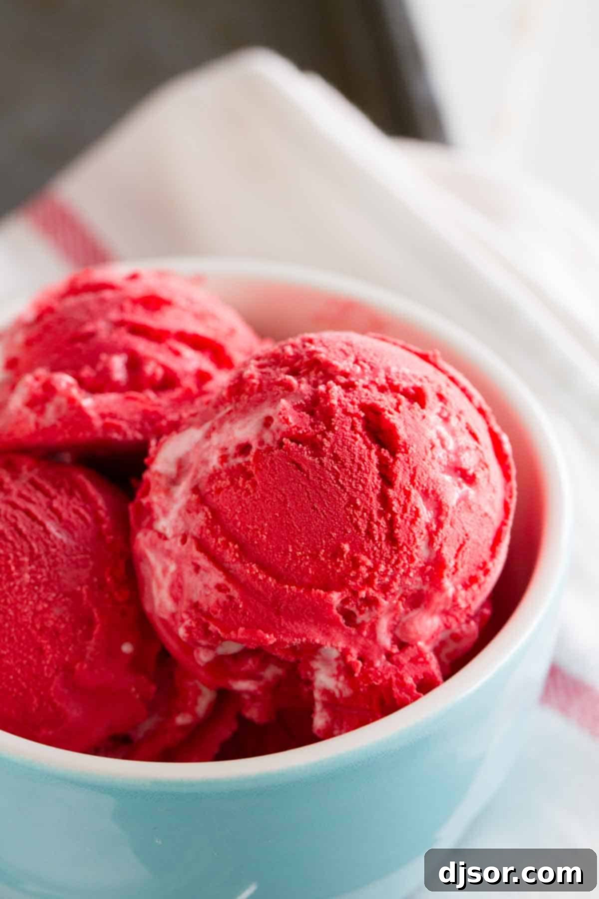 Close-up photo revealing the smooth, creamy texture of red velvet ice cream with subtle marshmallow swirls