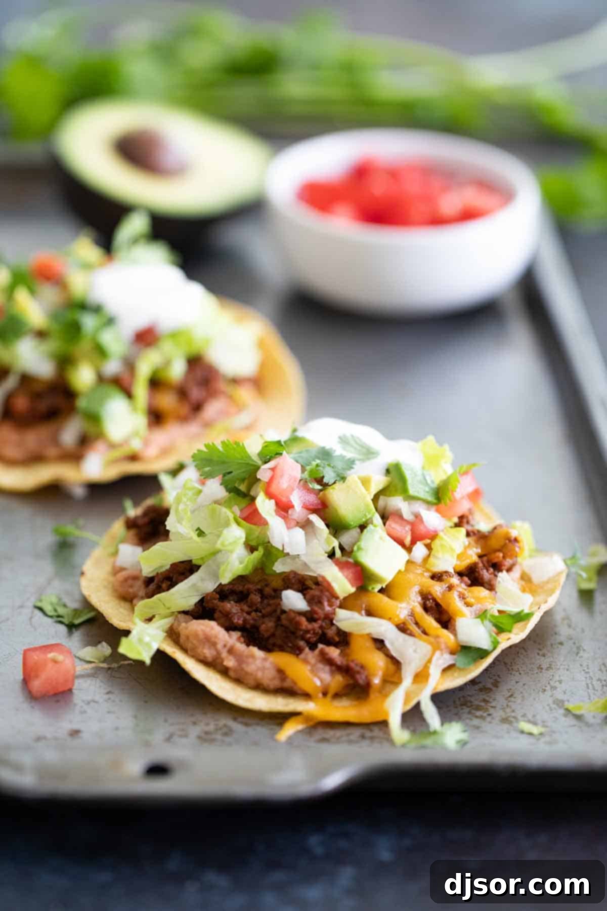 Beautifully assembled ground beef tostada with an array of fresh toppings