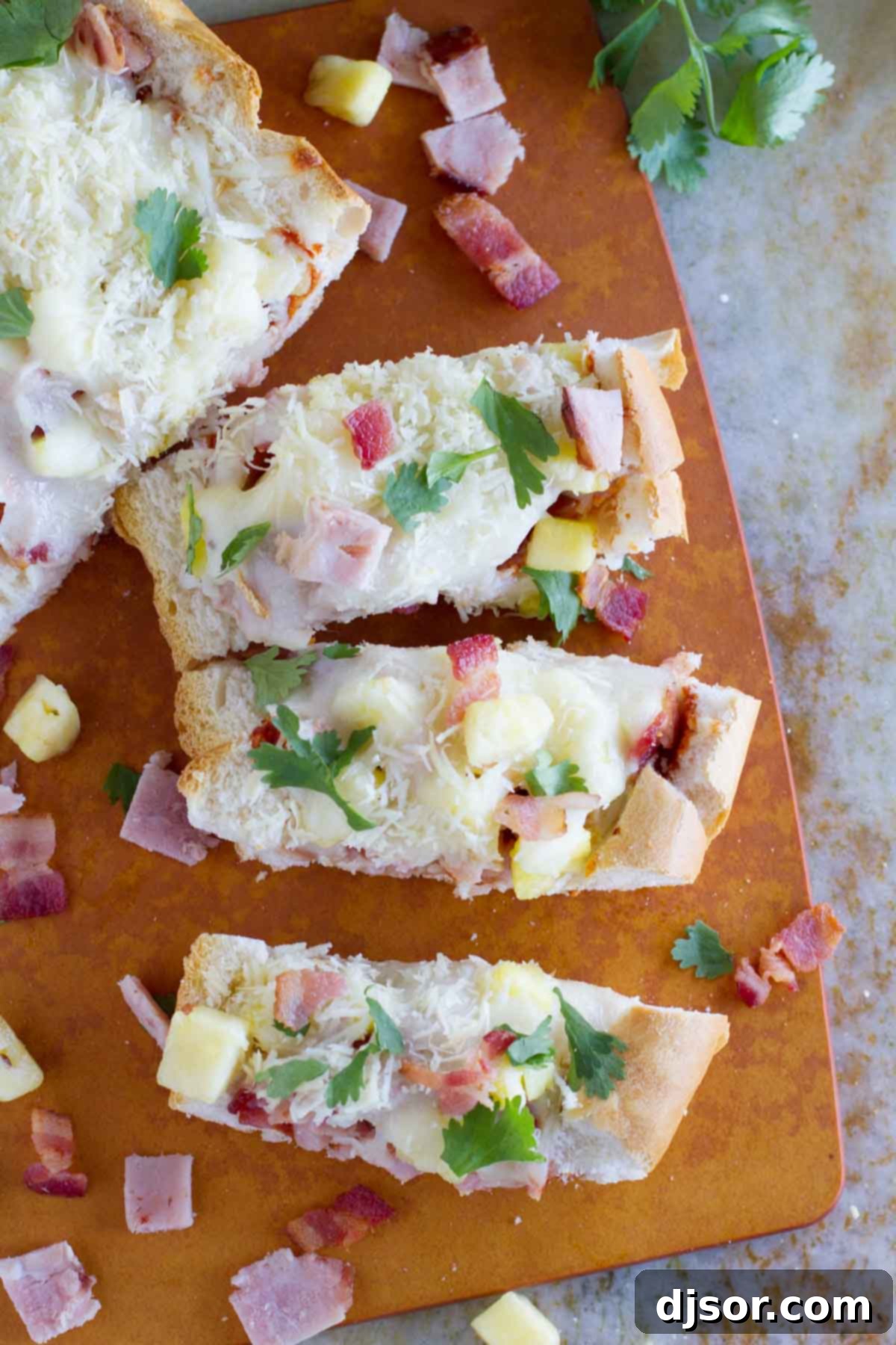 Tropical French Bread Pizza 3 French Bread Hawaiian Pizza cut into individual slices, ready to be served.