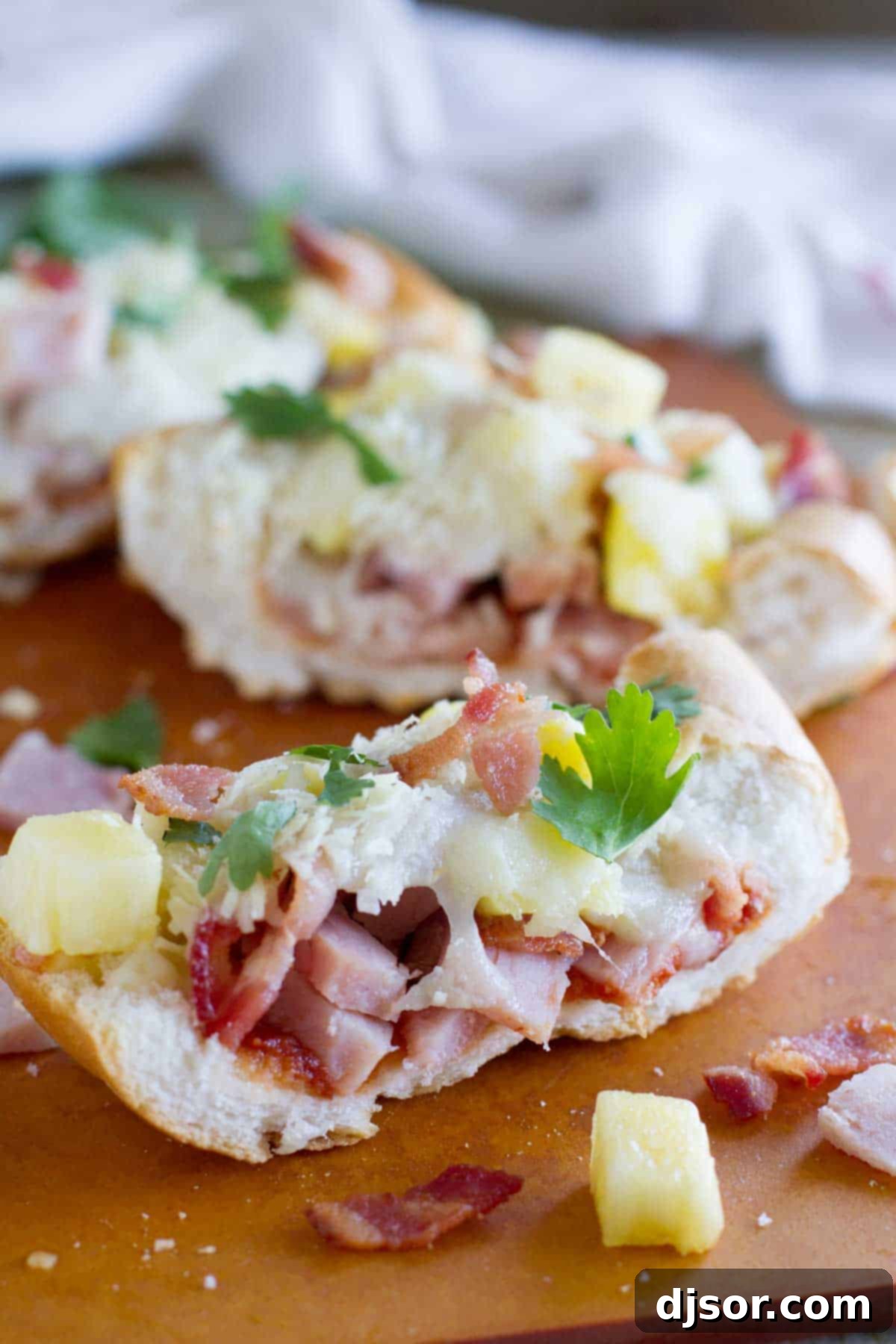 Tropical French Bread Pizza 4 A delectable slice of French Bread Hawaiian Pizza, showcasing layers of ham, pineapple, and crispy bacon.