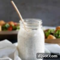 mason jar of homemade ranch dressing with salads in the background