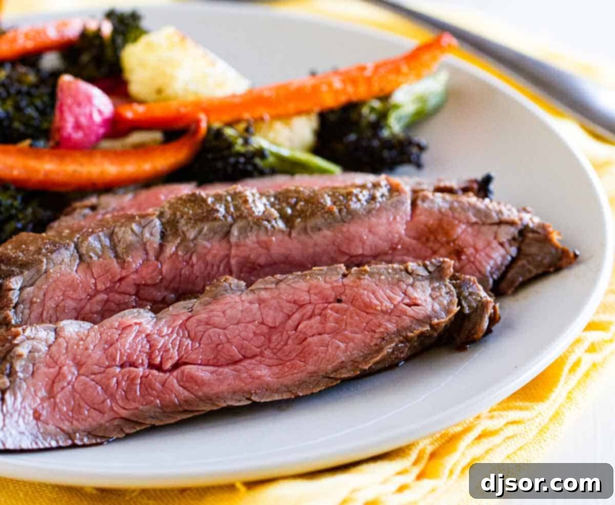 Delicious Balsamic Grilled Flank Steak: An Easy & Flavorful Dinner Idea sliced grilled flank steak on a plate with fresh vegetables, showcasing a perfect medium-rare doneness