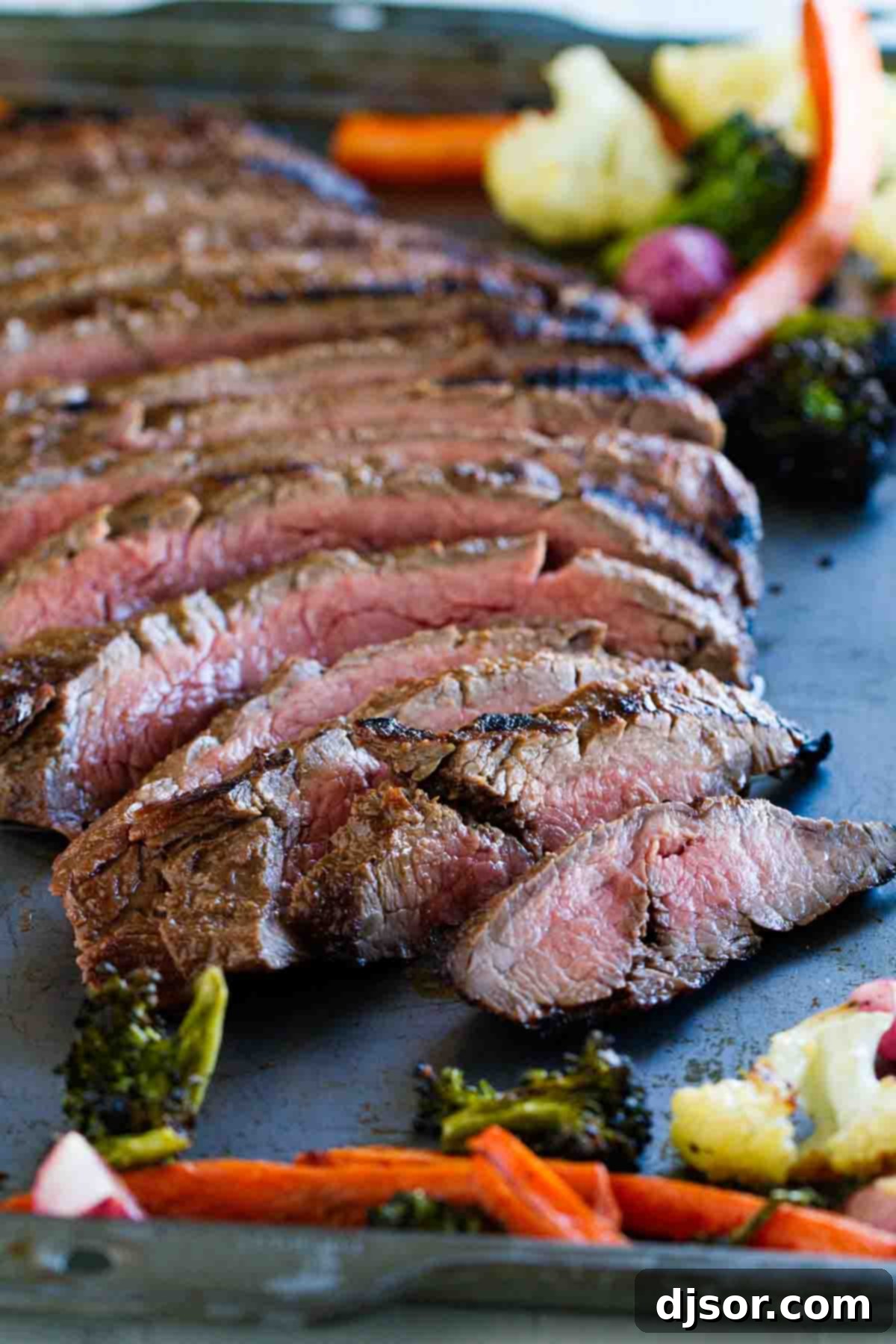 Achieving Perfect Tenderness with Balsamic Grilled Flank Steak full grilled flank steak, perfectly seared and sliced on a baking sheet, ready to be served