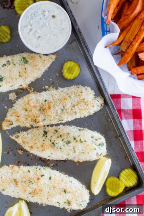 Three pieces of golden-brown panko-crusted fish, served with a side of creamy homemade tartar sauce and lemon slices.