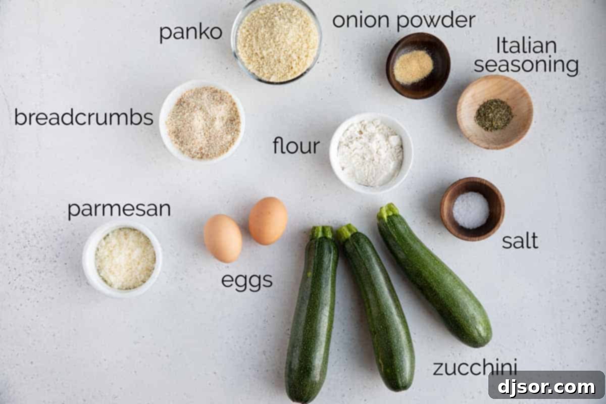 A collection of fresh ingredients laid out, ready for making crispy baked zucchini fries, including zucchini, flour, eggs, and breadcrumbs.