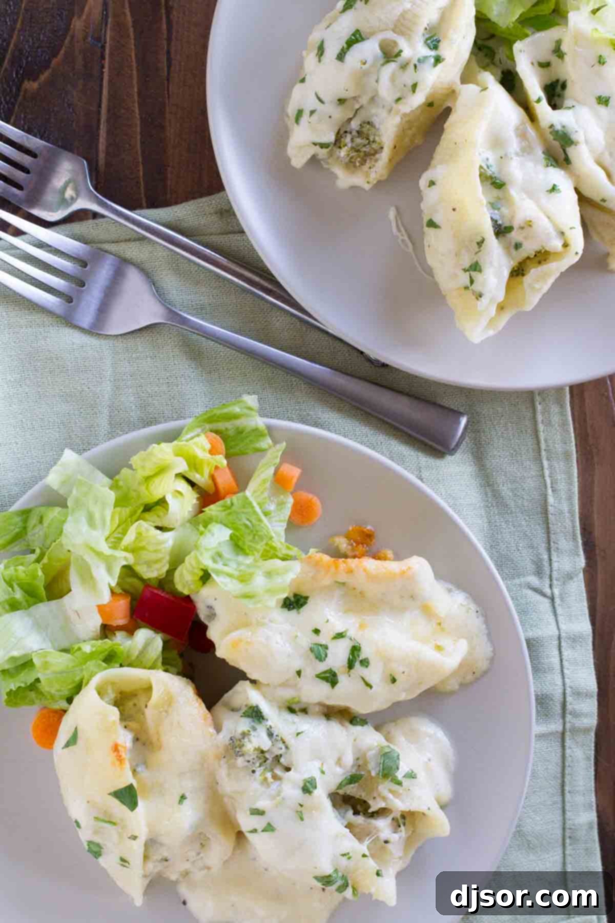 Chicken Alfredo Stuffed Shells Serving Idea overhead view of plates with chicken alfredo stuffed shells and fresh parsley garnish