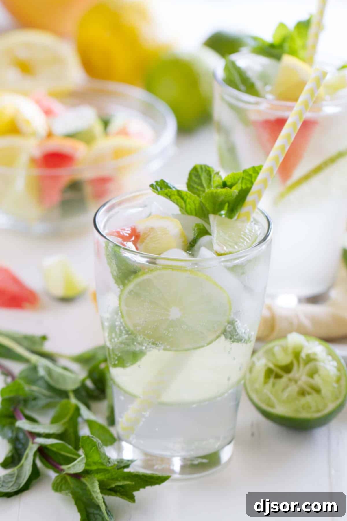 Virgin Mojito (Nojito) served in a tall glass with a striped straw, garnished with fresh mint and citrus slices.