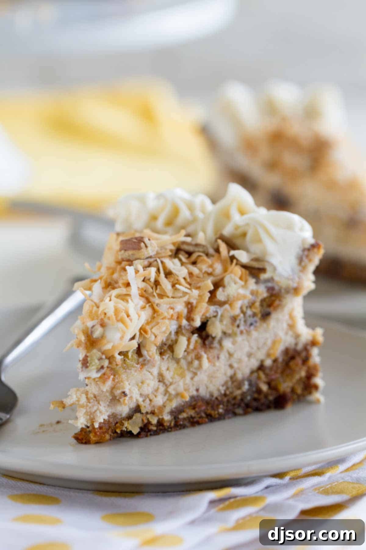 Experience the ultimate dessert fusion with our Carrot Cake Cheesecake: two layers of classic carrot cake embracing a creamy cinnamon cheesecake filling, adorned with toasted coconut and pecans. A delectable slice of Carrot Cake Cheesecake, showcasing its distinct layers, topped with toasted coconut and served on a elegant white plate. This dessert combines the best of moist carrot cake with creamy cinnamon cheesecake.