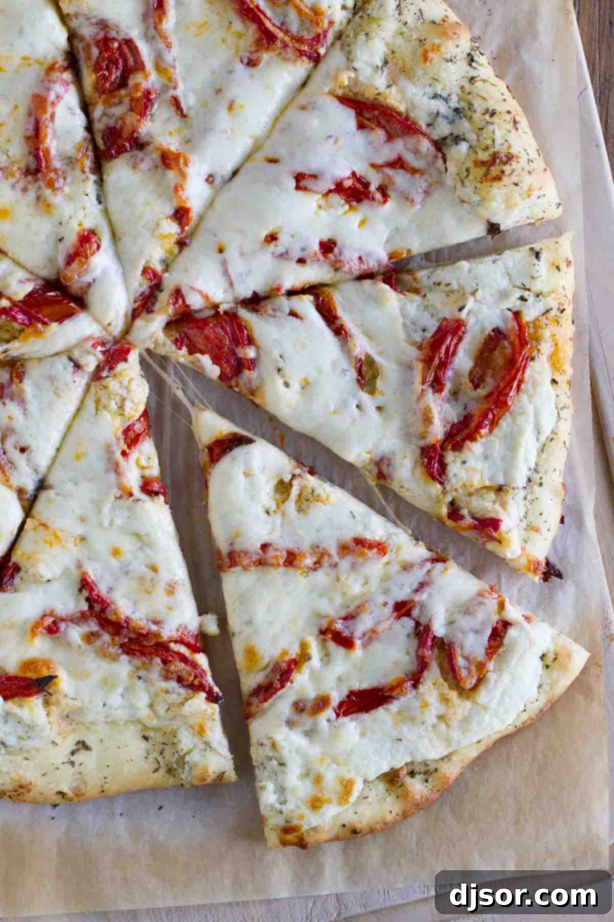 Crafting Your Ultimate White Pizza overhead view of a white pizza with roasted tomatoes cut into slices
