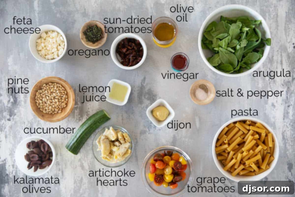 A vibrant selection of ingredients for Mediterranean Pasta Salad, including fresh vegetables, pasta, and herbs, arranged on a countertop.