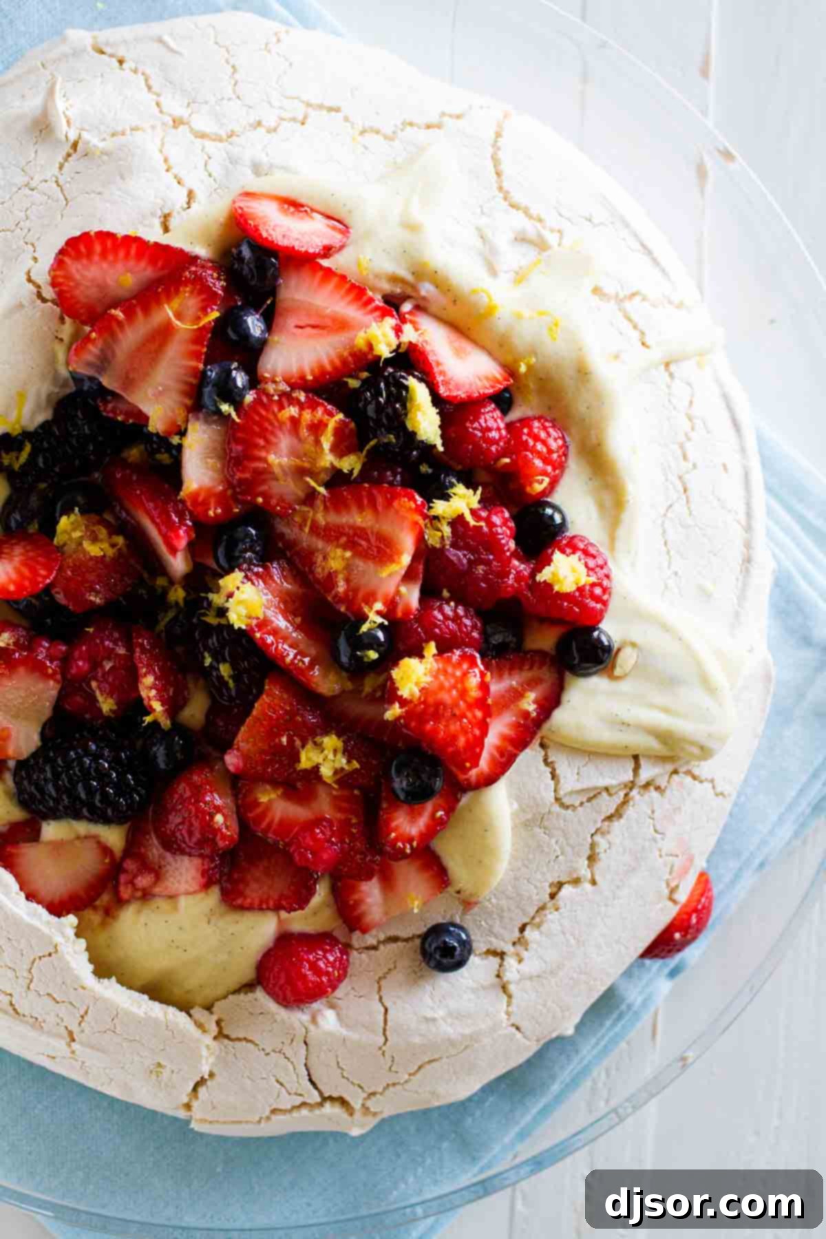 fresh berries with lemon zest on top of a pavlova