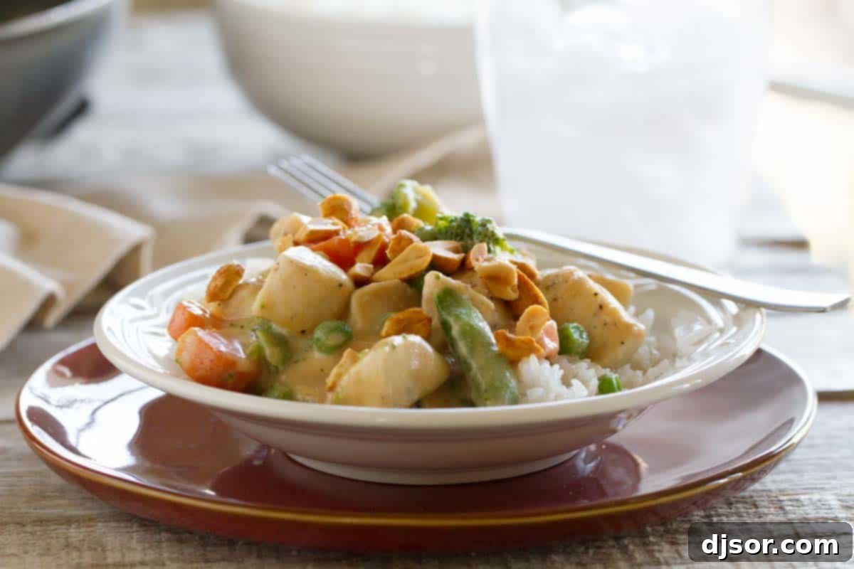 Peanut sauce doesn’t have to be reserved for satay - this Peanut Chicken Stir Fry has a coconut milk and peanut sauce, lean chicken breasts, and lots of veggies. It is the perfect weeknight dinner. Bowl with a serving of peanut chicken stir fry topped with chopped peanuts