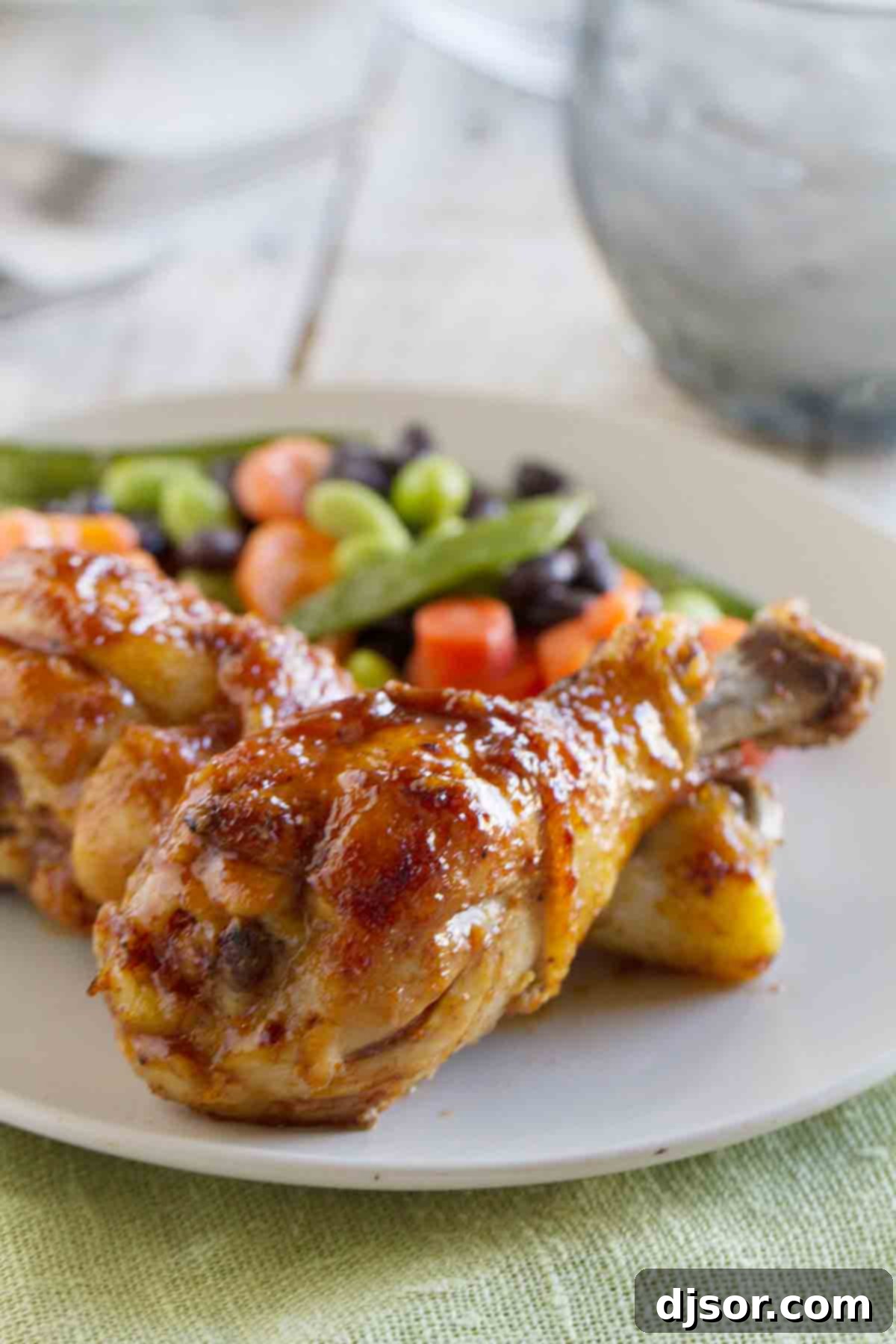 Sticky and sweet, these Honey Balsamic Drumsticks will be a meal that the whole family will devour! Plus a review of 400 Calories or Less with Our Best Bites. Delicious Honey Balsamic Chicken Drumsticks on a plate with vibrant vegetables, ready to be devoured by the whole family.