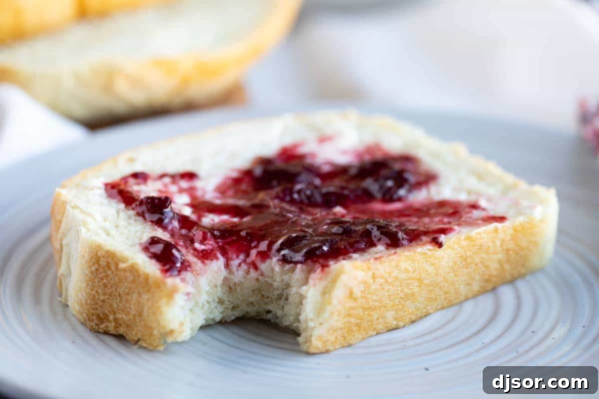 This may be the perfect sandwich bread! This Potato Bread is made with mashed potatoes which make for a loaf of bread that is sturdy, yet soft and fluffy. slice of Potato Bread topped with butter and jam