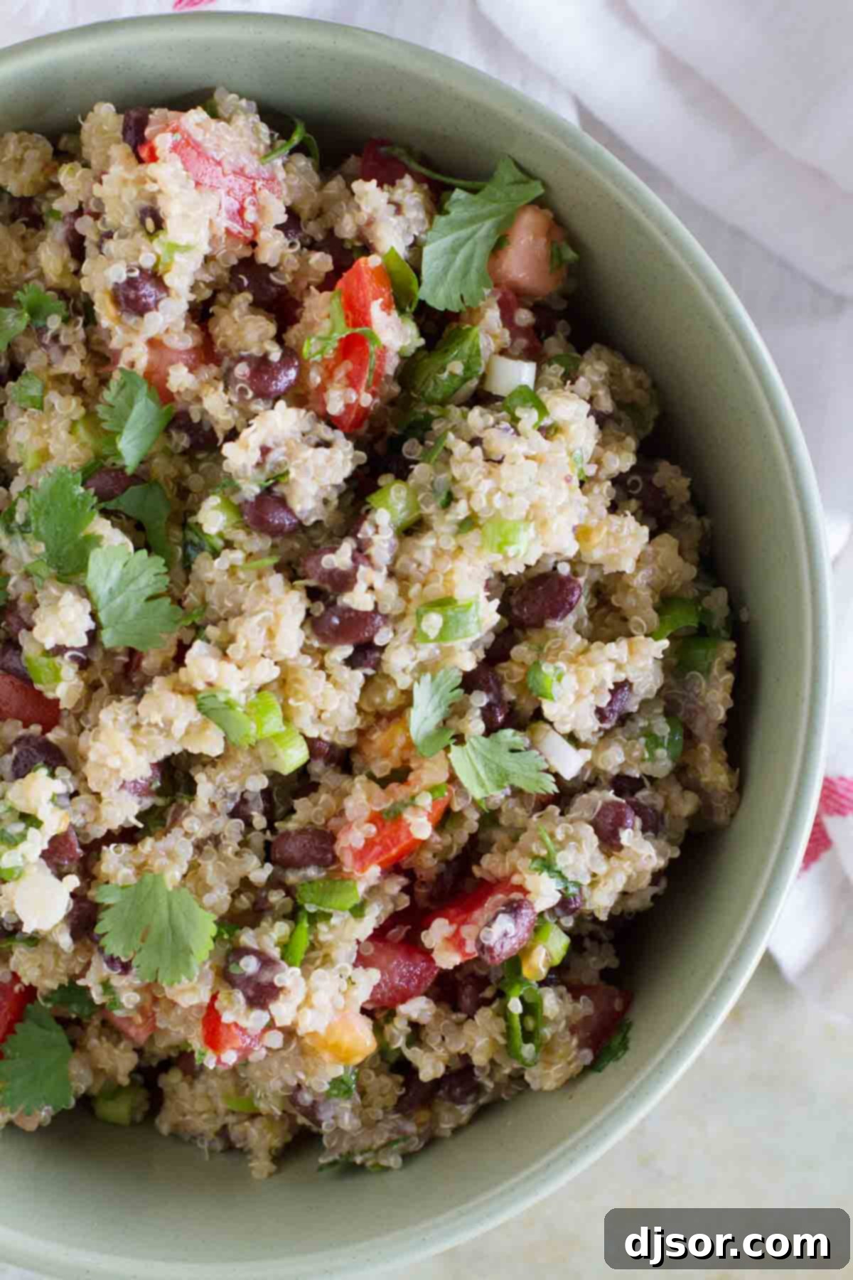 A vibrant green bowl brimming with delicious Tomato and Black Bean Quinoa Salad.