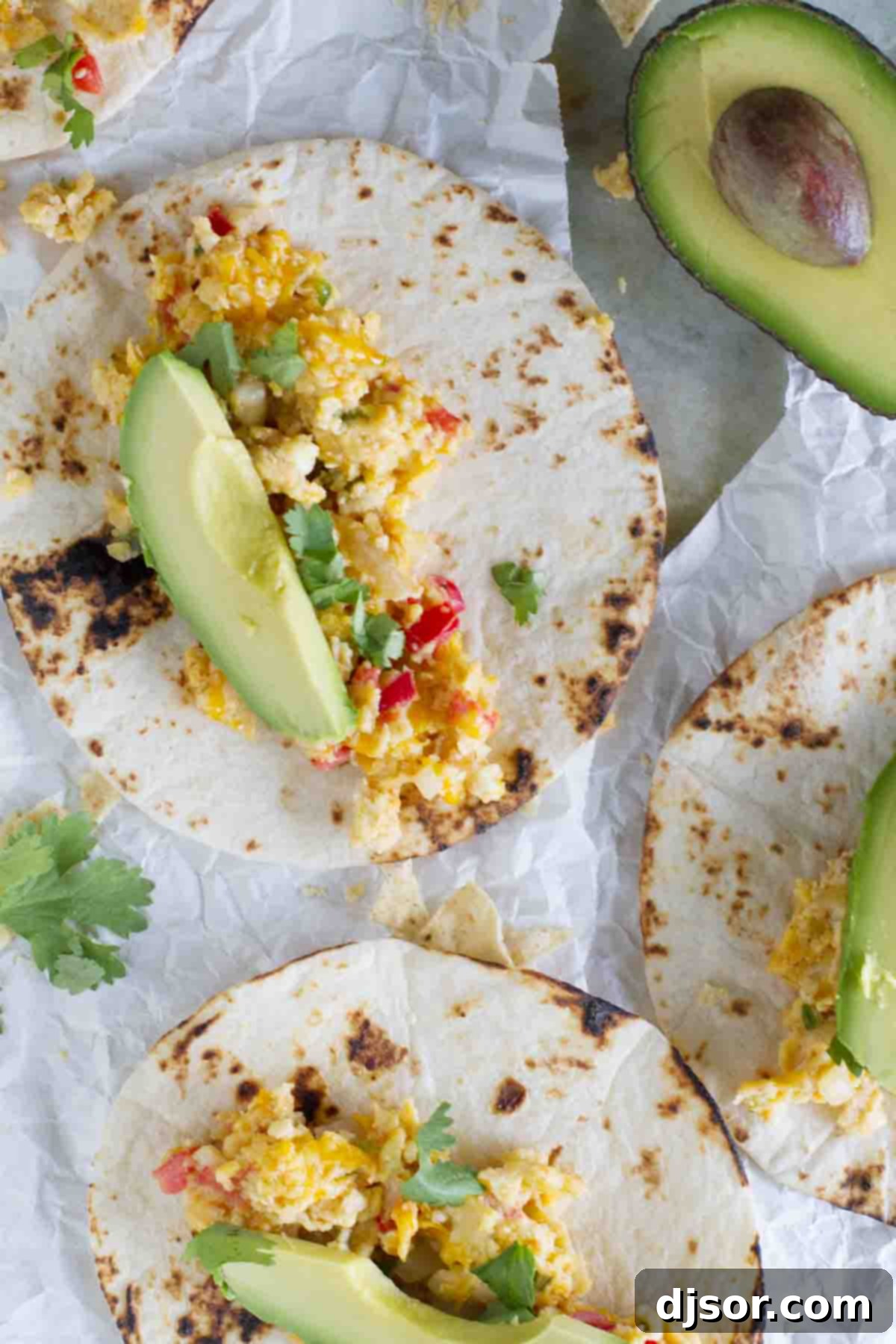 Ready-to-Eat Migas Tacos: A Breakfast Feast Assembled migas tacos with eggs, tomatoes, tortilla chips, avocado, and cilantro