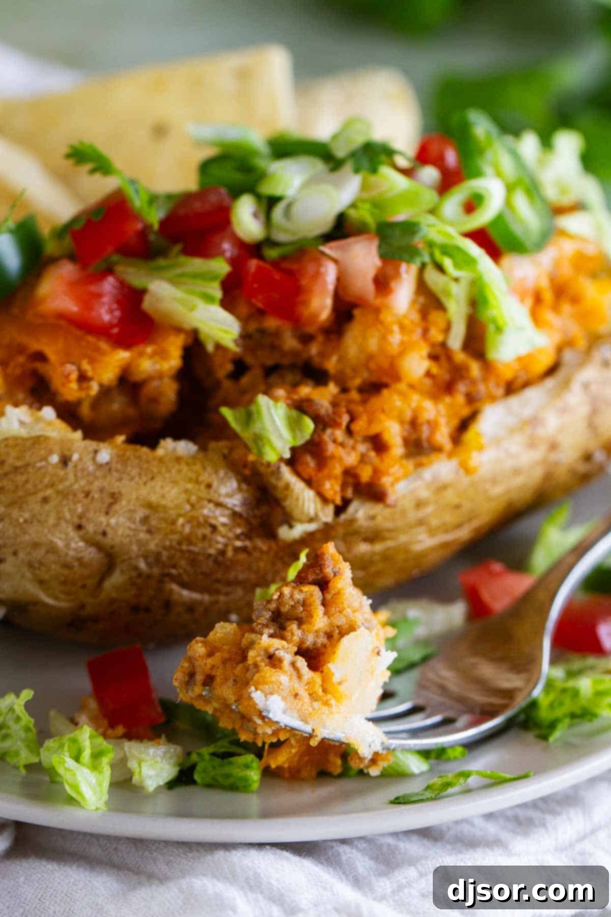 Taco stuffed potato with a bite taken from it.