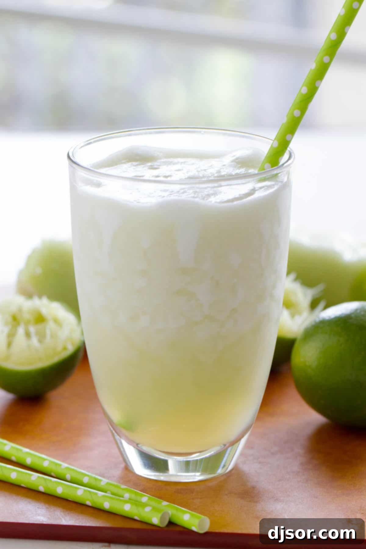 Zesty Melon Cooler 2 A refreshing Honeydew Lime Smoothie served in a glass, with fresh limes artfully placed in the background, hinting at the zesty flavor.