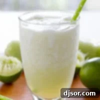 Zesty Melon Cooler 4 Honeydew Lime Smoothie with limes in the background.