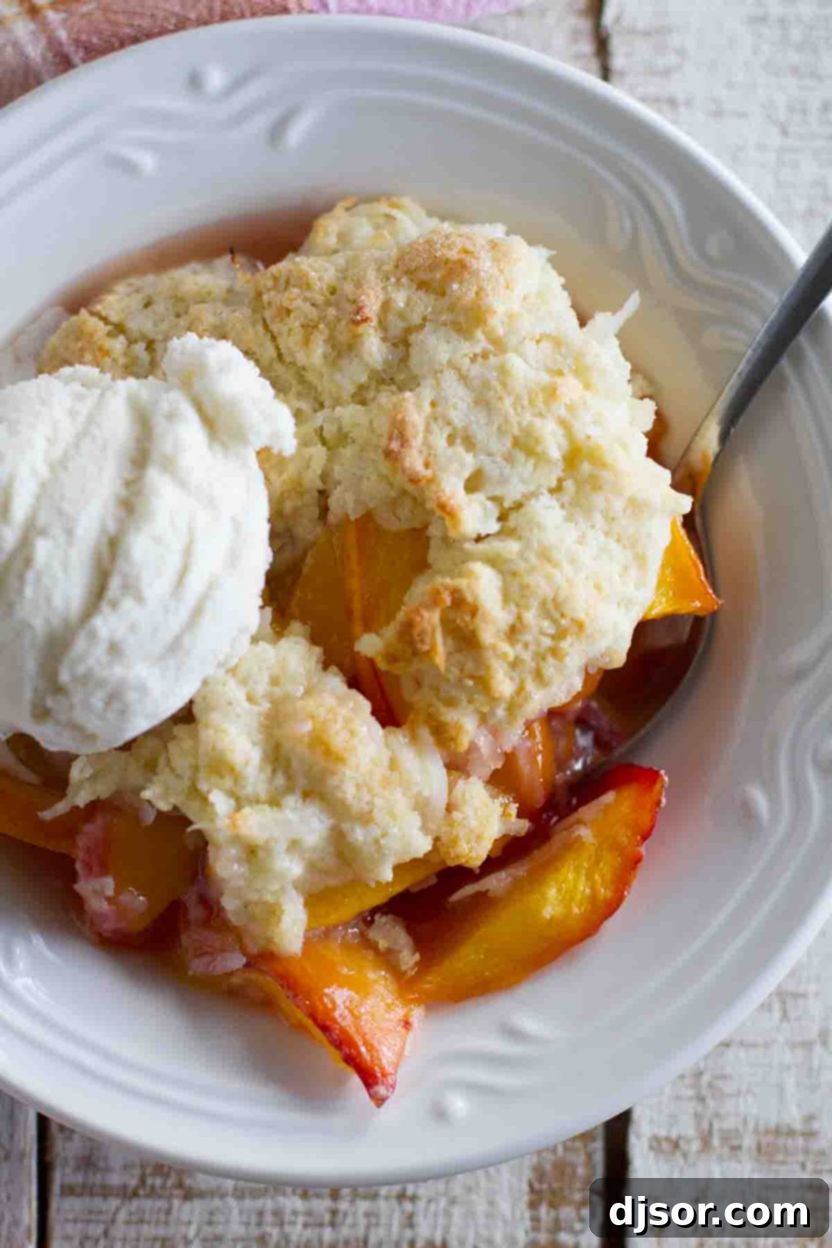 peach cobbler with coconut with a scoop of vanilla ice cream