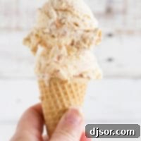 Ice cream cone with salted caramel ice cream with fudge and toasted coconut.