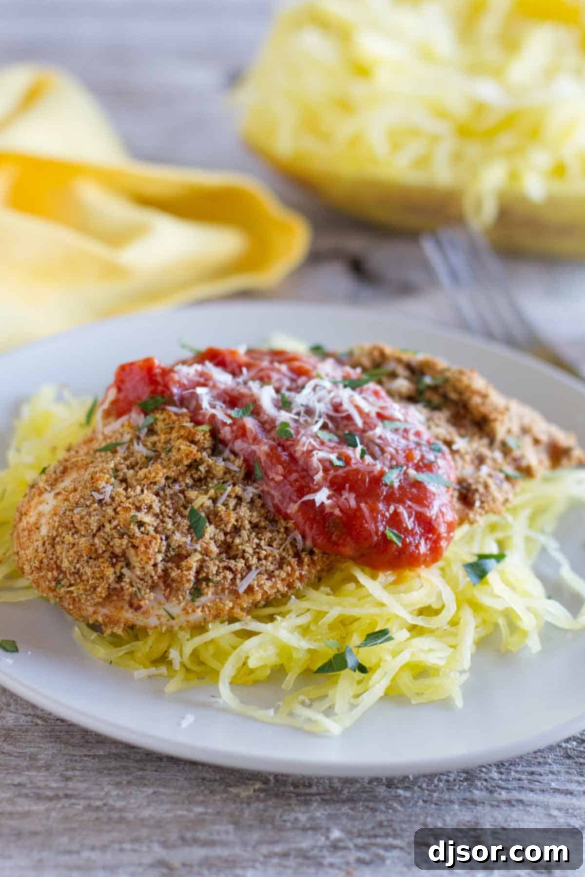 Baked Chicken Parmesan with rich tomato sauce and fresh herbs, served on a plate.