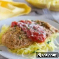 Baked Chicken Parmesan with tomato sauce and herbs.