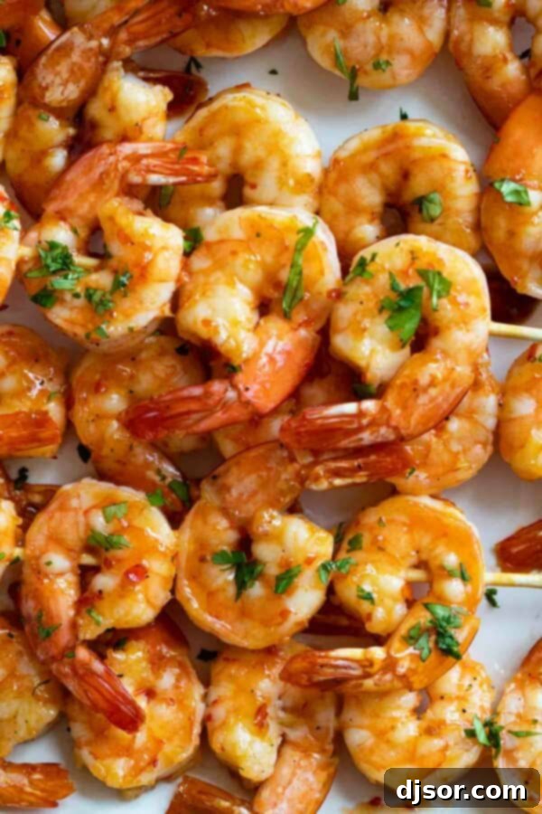 Chili Honey Garlic Shrimp Kabobs stacked on a plate.