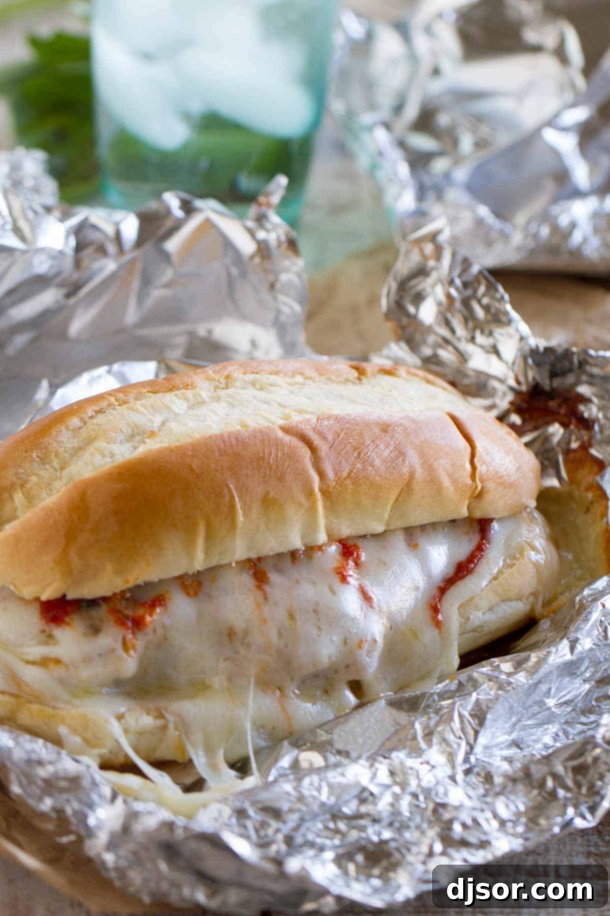 Baked Chicken Parmesan Sandwiches baked in a foil packet, showing the crispy breading and melted cheese.