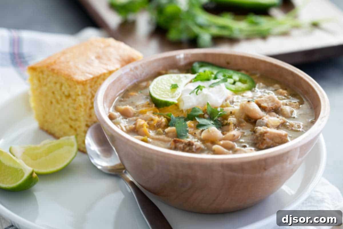 bowl of white turkey chili with cornbread and lime slices