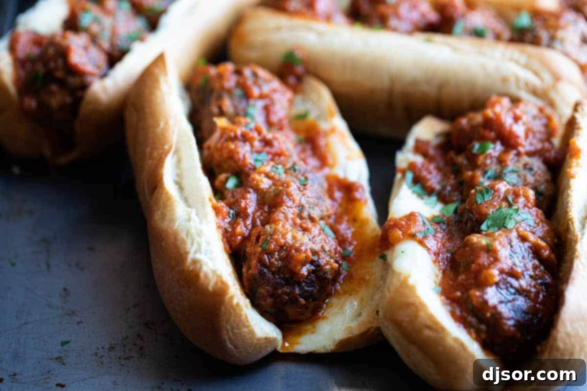 Homemade Meatball Sub: Beef and Pork Meatballs with Marinara and Cheese Delicious homemade meatball subs with marinara sauce and melted provolone cheese, ready to serve.