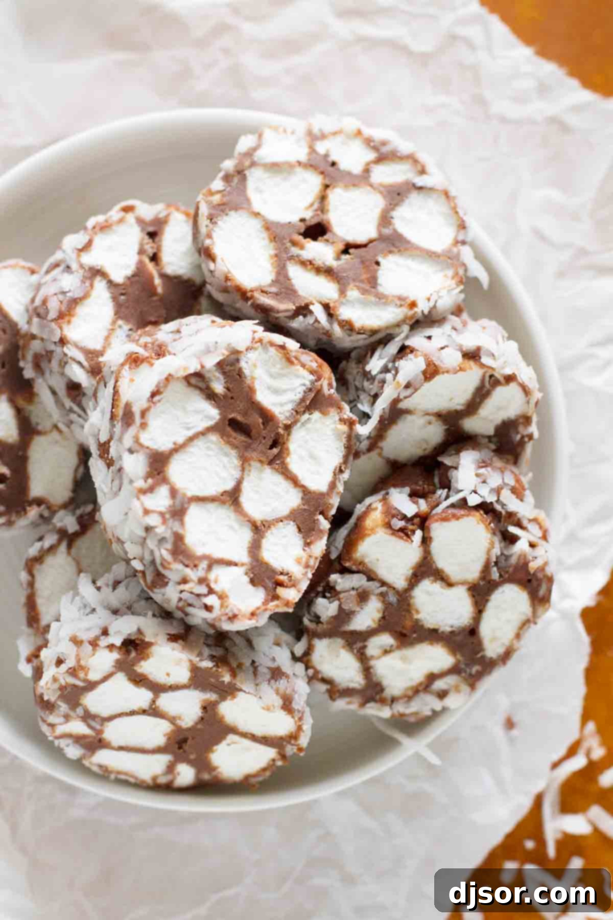 A close-up shot of Shaggy Dog Candy pieces piled in a small, rustic bowl, showcasing their inviting texture and coconut coating.
