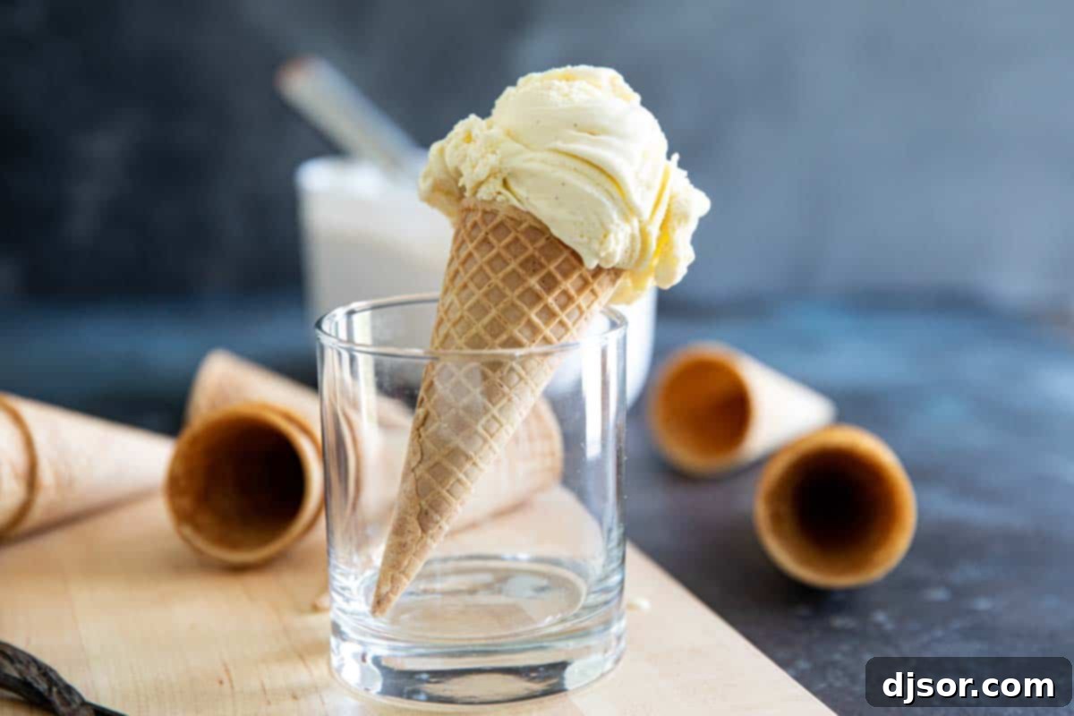 Vanilla ice cream scoop in a sugar cone, resting in a glass