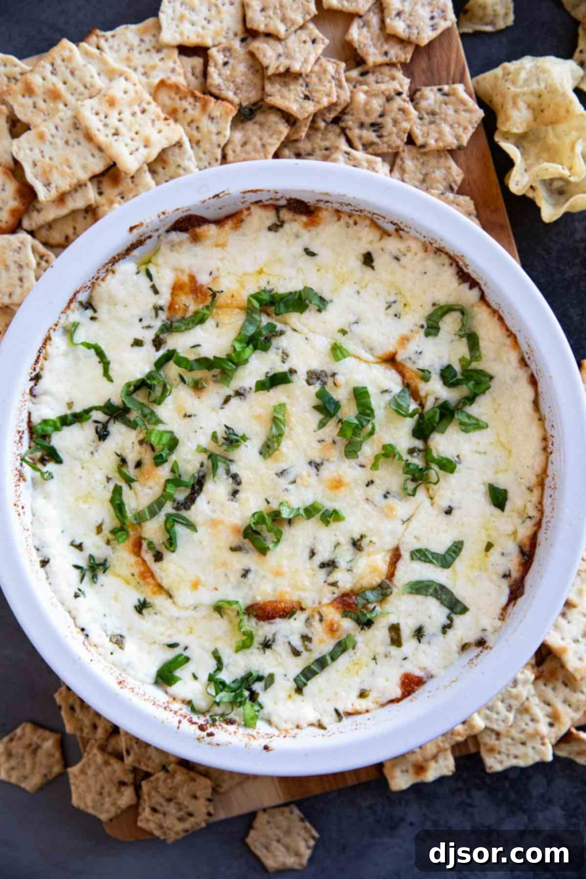 Creamy White Cheese Dip 7 White pie dish filled with white cheese dip, topped with fresh basil.