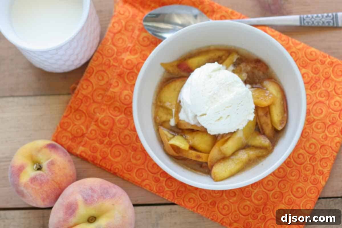 Warm scalloped peaches cooked in a slow cooker, served in a bowl with a melting scoop of vanilla ice cream, ready to be enjoyed as a comforting dessert.
