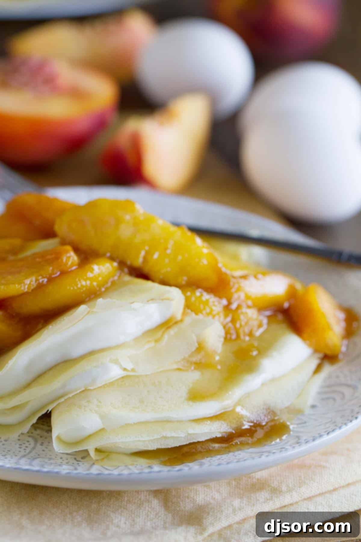 Simple Crepe Recipe with Peaches and Cream - A perfect blend of smooth crepes, rich cream cheese, and sweet peaches. crepes filled with a cream cheese mixture and topped with sauteed peaches