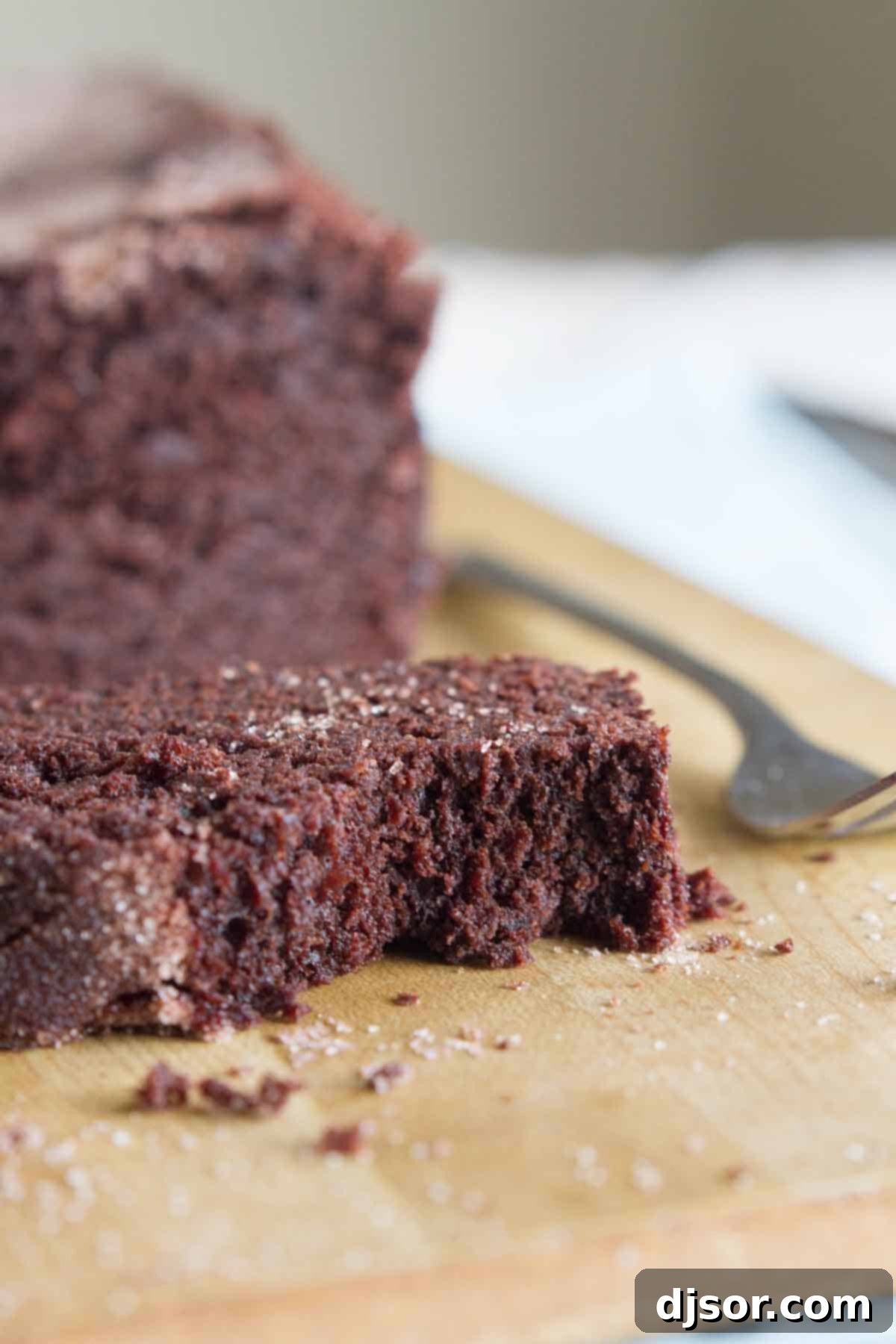 Chocolate Cinnamon Swirl Bread 5 A single slice of chocolate cinnamon bread, with a corner gently bitten, showing off the perfectly baked interior and golden-brown crunchy topping.
