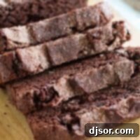 Chocolate Cinnamon Swirl Bread 6 A perfectly baked loaf of sliced chocolate cinnamon bread resting on a rustic wooden cutting board, ready to be served.