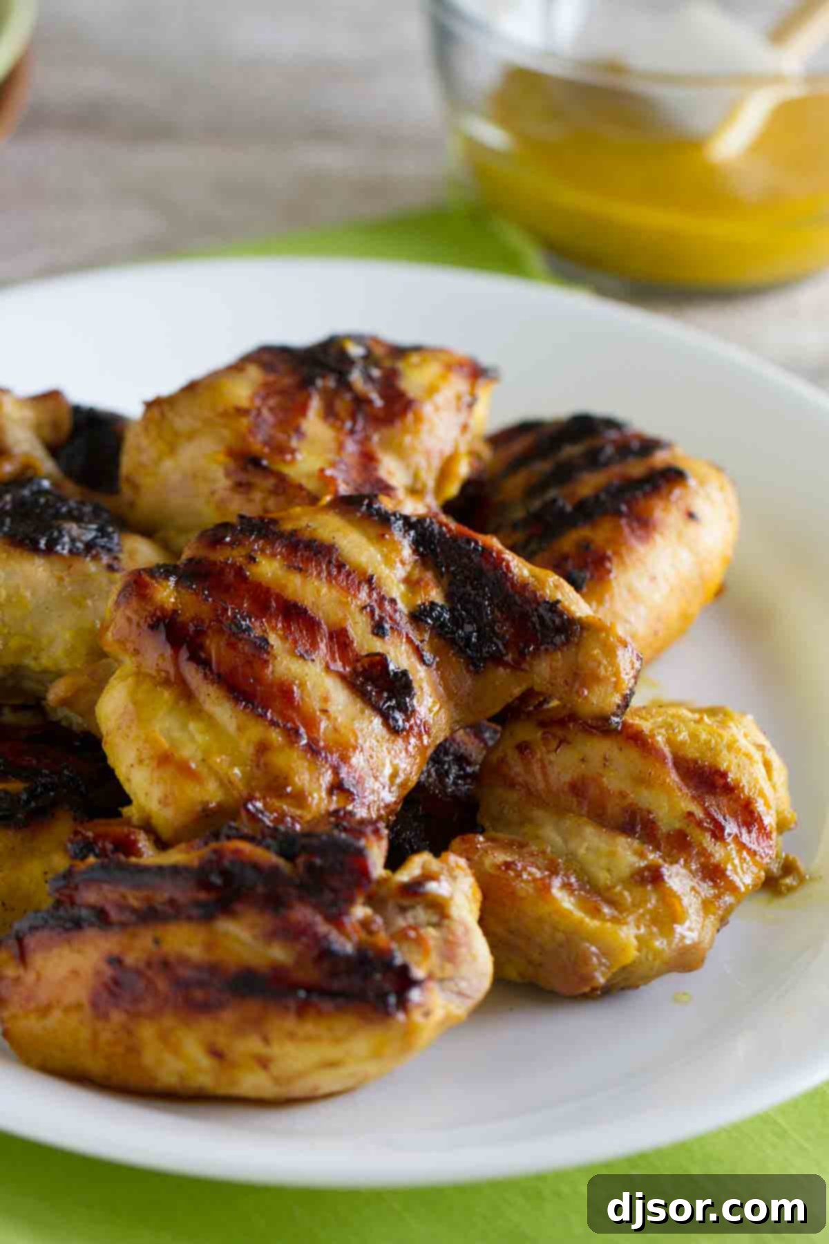 Grilled Brown Sugar Mustard Chicken stacked on a plate, showcasing its golden-brown glaze and inviting texture.