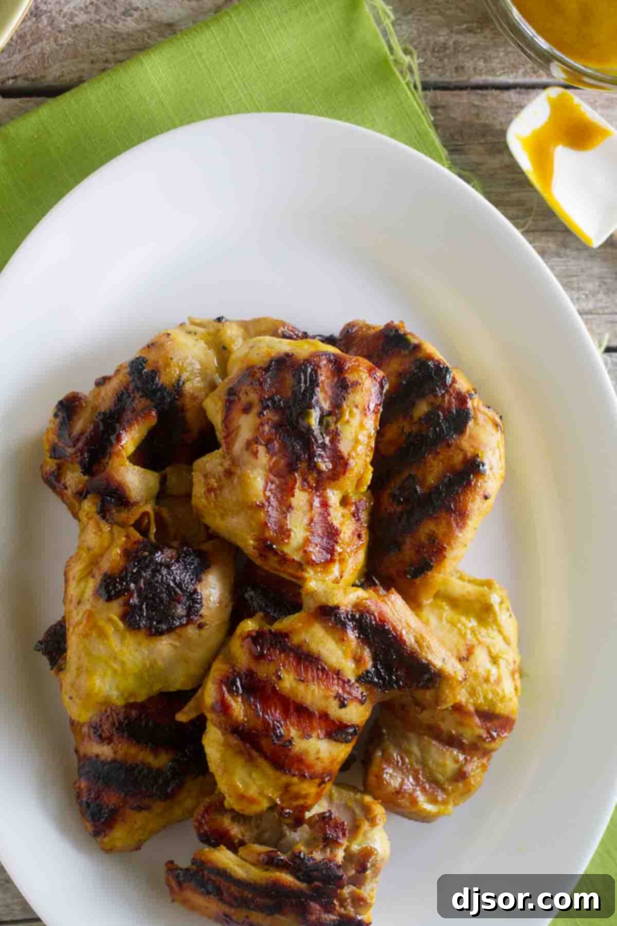 A vibrant platter of Grilled Brown Sugar Mustard Chicken, garnished and ready for serving, highlighting its golden exterior.