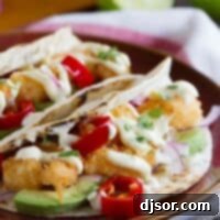 Zesty Crispy Shrimp Tacos 5 Two crispy shrimp tacos topped with homemade mayonnaise on a plate.