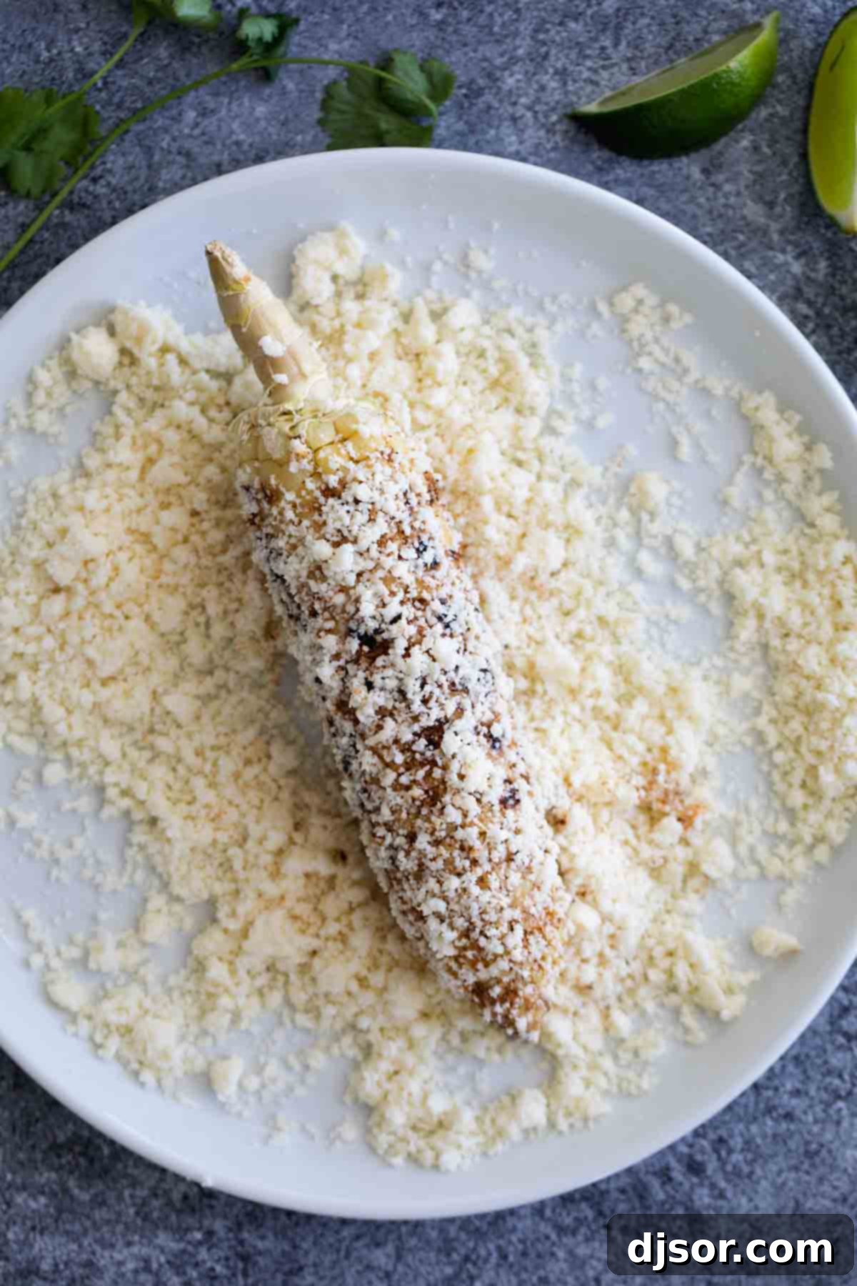 Grilled corn - south of the border style! This Grilled Mexican Corn on the Cob takes grilled corn to the next level with spices, crumbled Cotija cheese, cilantro and fresh squeezed lime. Perfectly grilled corn cobs generously covered in crumbled Cotija cheese, ready to be served.