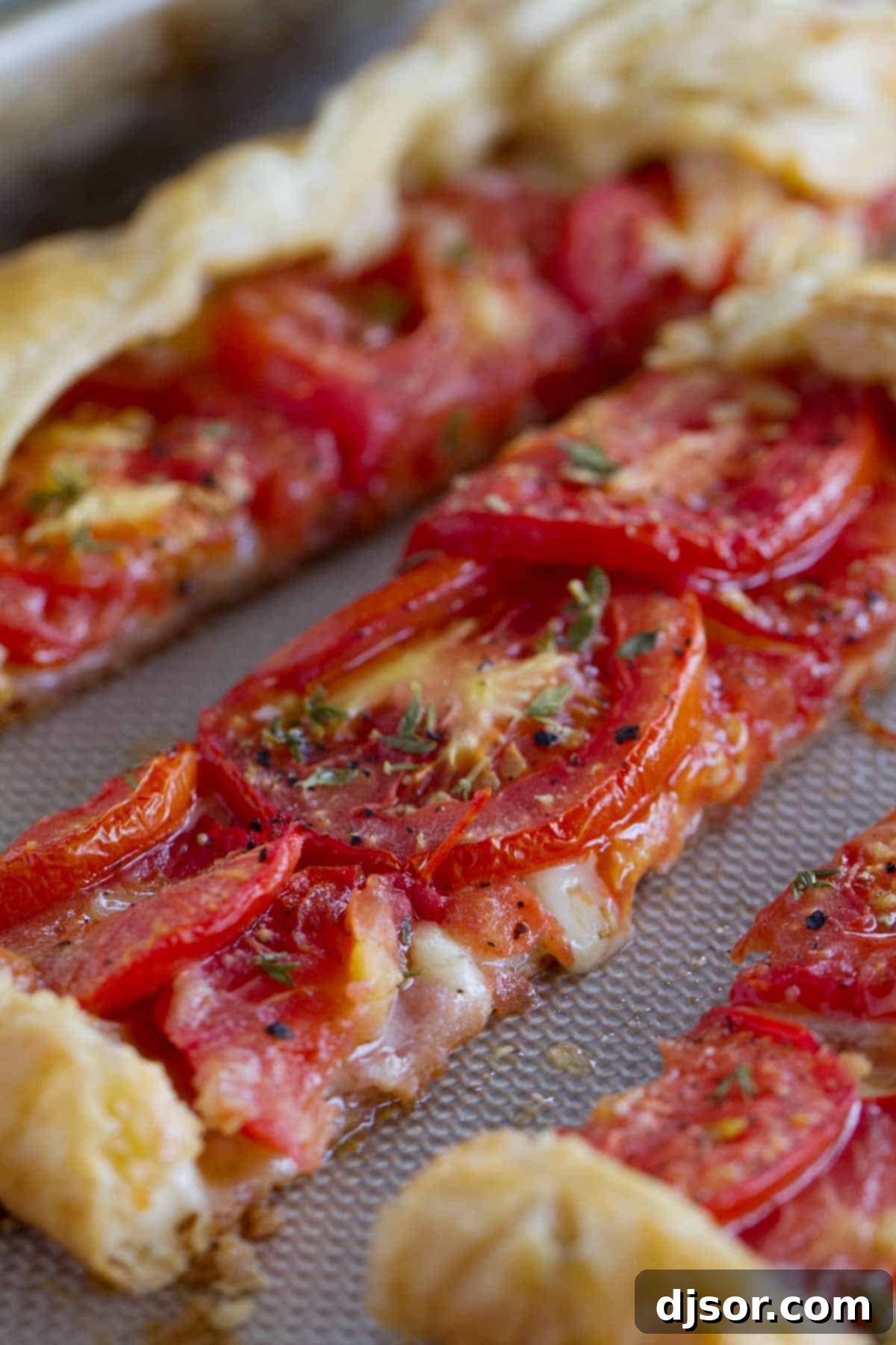 Three slices of Tomato Tart with Bacon and Gruyere on a cutting board, showing the layers of ingredients.