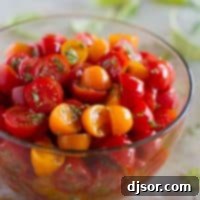Aromatic Tomato and Herb Salad 2 A vibrant bowl of yellow and red grape tomatoes generously mixed with fresh herbs, showcasing the simple beauty of a Herbed Tomato Salad.