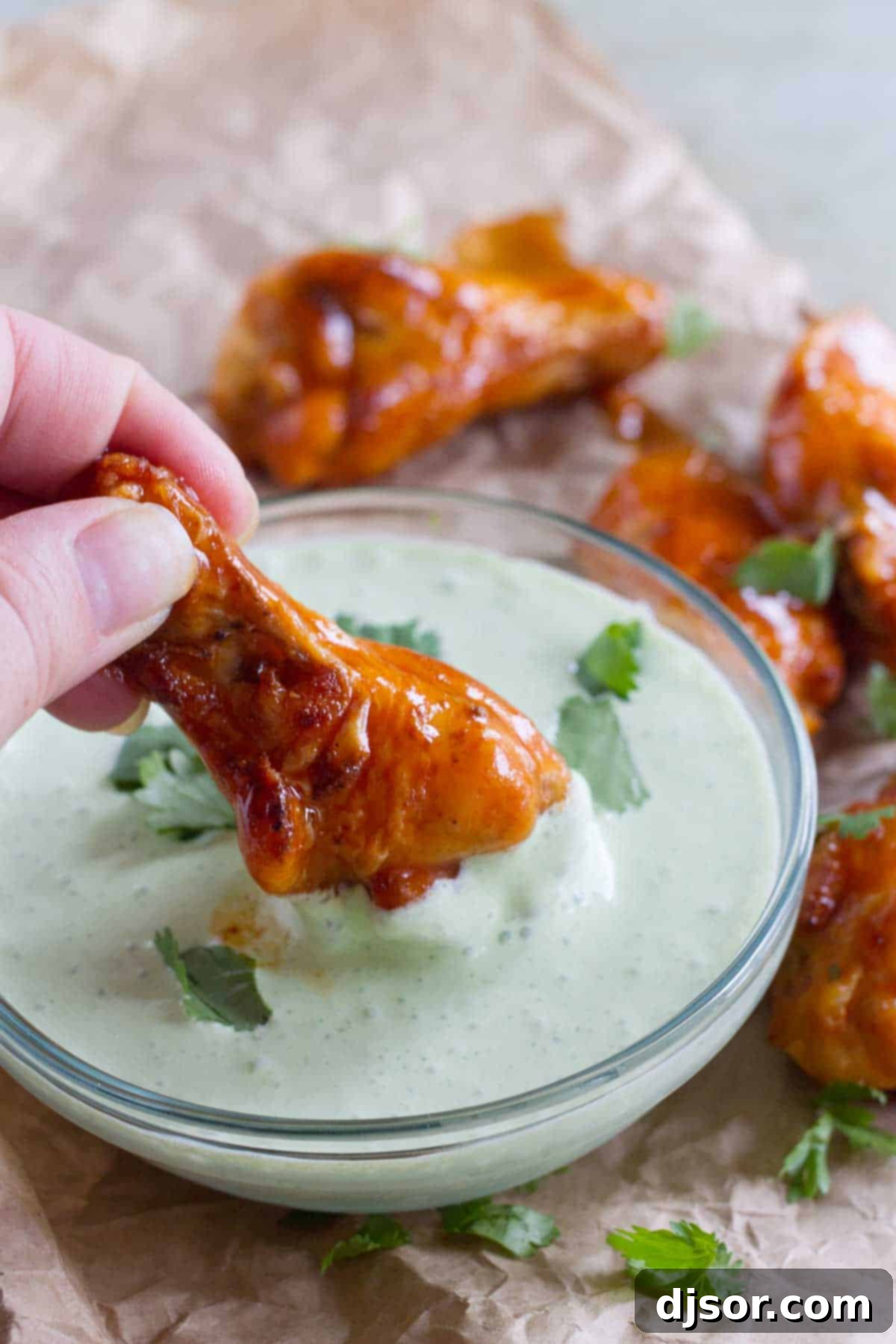Enchilada Inspired Chicken Wings 7 Dipping an enchilada chicken wing into creamy cilantro dip.