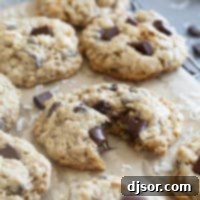 Chocolate Chunk Oatmeal Coconut Cookies on a cooling rack, with one cookie broken in half.