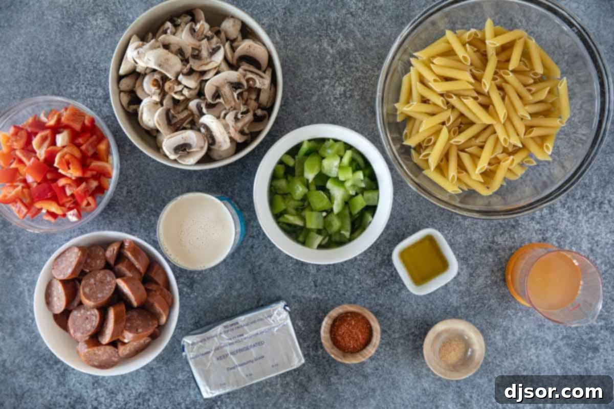 Hearty Cajun Sausage Pasta 3 Ingredients for Cajun Sausage Pasta laid out on a cutting board.