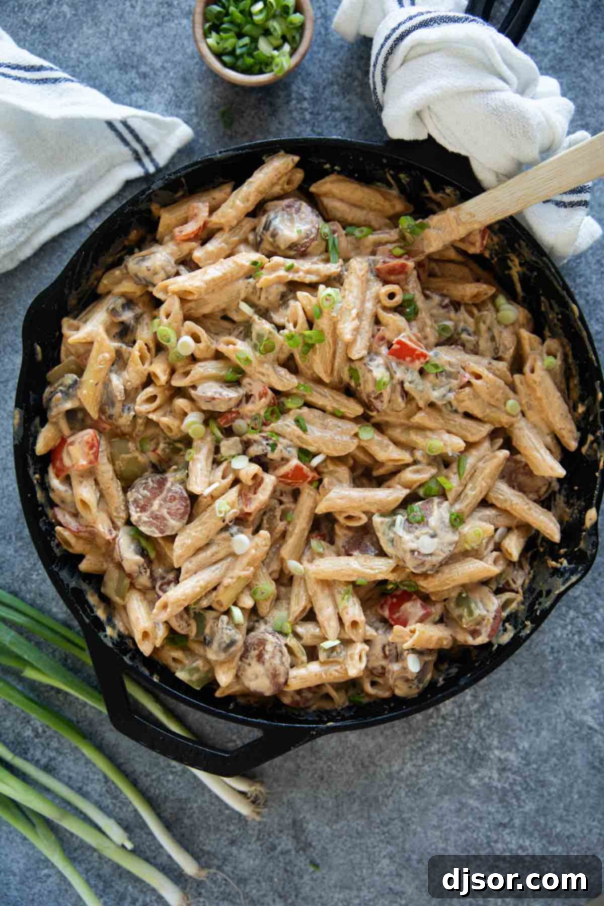 Hearty Cajun Sausage Pasta 7 Cajun Sausage Pasta served in a cast iron skillet, ready to eat.